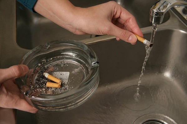 한 흡연자가 담배꽁초에 물을 뿌려 남은 불씨를 제거하고 있다. (사진 출처: 미 연방 소방국)