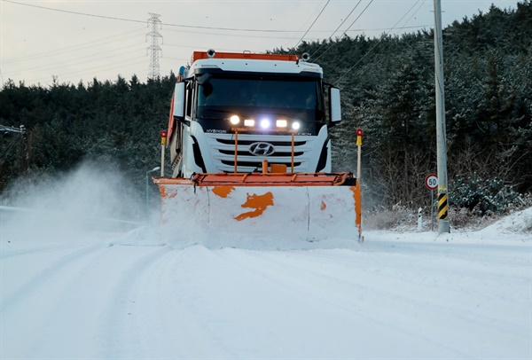 13일 오전 충남 지역에 눈이 내린 가운데, 한 제설차가 태안 도로에 쌓인 눈을 치우고 있다.