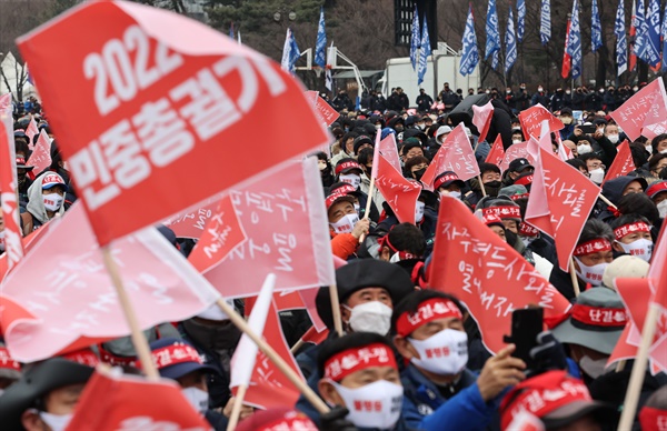 15일 오후 서울 여의도공원에서 열린 2022 민중총궐기 대회에서 참가자들이 깃발을 흔들고 있다.