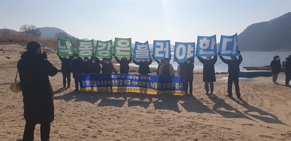 환경운동연합 활동가들이 합천보 상류 우산리 선착장 부근 모래톱에서 합천보 수문개방 연장 촉구 기자회견을 열고 있다. 