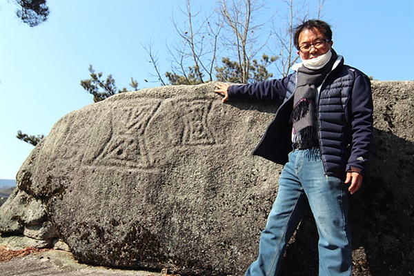 남원 향토사학자 김용근씨가 돼지처럼 생겨 일명 '돼지바위'라 불린 바위 전면에 새겨진 암각화에 대해 설명하고 있다
