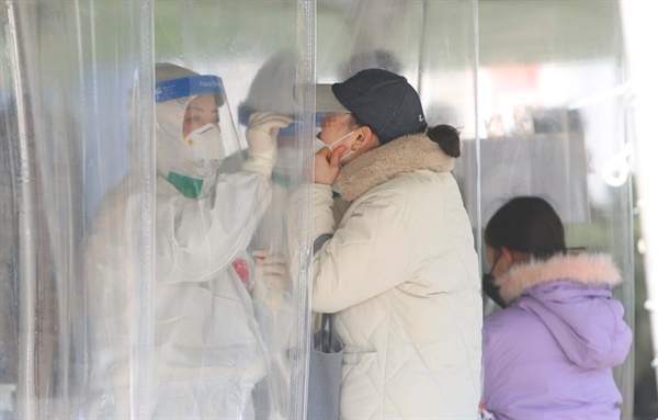21일 오전 대구 중구 국채보상공원에 마련된 임시선별진료소에서 시민들이 신종 코로나바이러스 감염증(코로나19) 검사를 받고 있다.