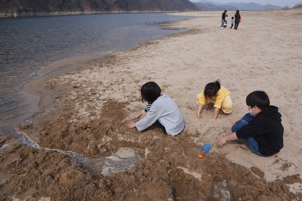 아직 겨울임에도 아이들이 신발을 벗고 모래성을 쌓으며 놀고 있다.
