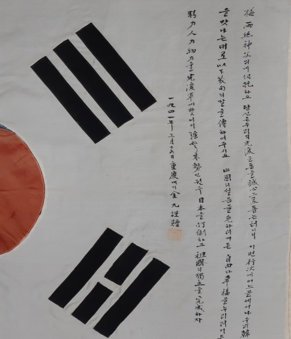 깃대와 괘의 사이에 김구 선생의 친필 4줄 143자가 쓰여 있고, 마지막에 김구(金九)라고 새겨진 네모난 도장이 찍혀있다