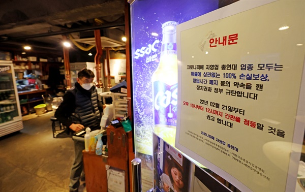 21일 서울 마포구 홍대입구역 인근 한 음식점이 영업 시간 제한 철폐와 자영업자 손실보상을 요구하며 제한 영업시간 오후 10시가 지난 뒤 점등시위를 하고 있다.