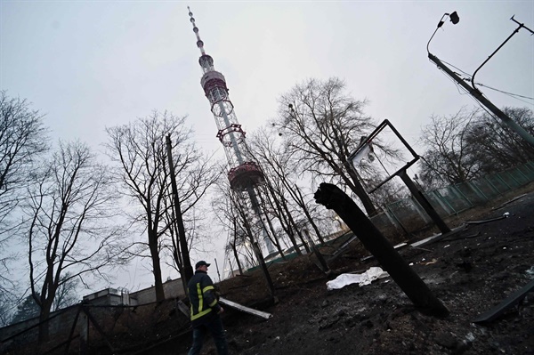 1일(우크라이나 현지시각) 키예프에 있는 메인 텔레비전 타워가 피격당한 뒤, 한 소방관이 현장의 미사일 파편을 지나가고 있다. 