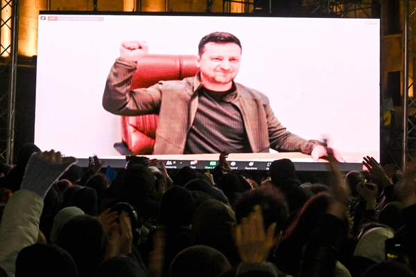 4일(현지시각) 우크라이나 트빌리시에서 시민들이 젤렌스키 우크라이나 대통령의 연설을 대형 스크린으로 지켜보고 있다. 