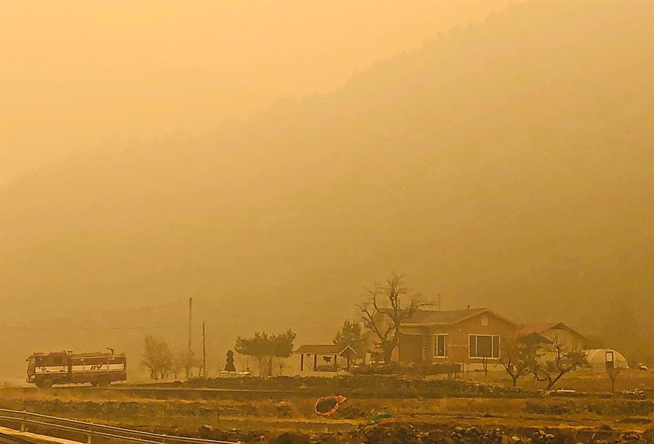 삼척산불이 확산중인 가운데 안개와 연기로 마을이 붉게 물들어 있다.