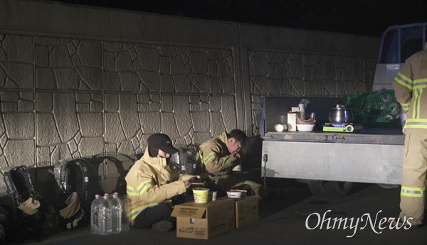 울진 산불이 5일째 확산하는 가운데 지난 7일 저녁 소방대원들이 잠시 휴식을 취하면서 라면을 먹고 있다.