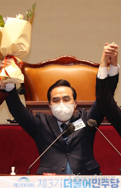 더불어민주당 신임 원내대표로 선출된 박홍근 의원이 24일 오후 서울 여의도 국회에서 열린 의원총회에서 꽃다발을 받아 들고 인사하고 있다.