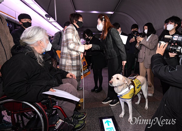 장혜영 정의당 의원(왼쪽)과 김예지 국민의힘 의원이 28일 서울 중구 충무로역 3호선 승강장에서 전국장애인차별철폐연대(전장연)의 25차 '출근길 지하철 탑니다'를 함께한 뒤 인사를 나누고 있다.