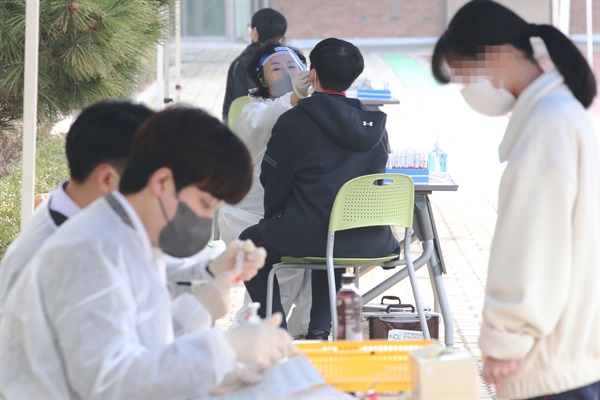 지난 3월 16일 오전 서울의 한 학교에 설치된 이동형 PCR 검사소에서 학생들이 검사를 받고 있다. 자료사진.