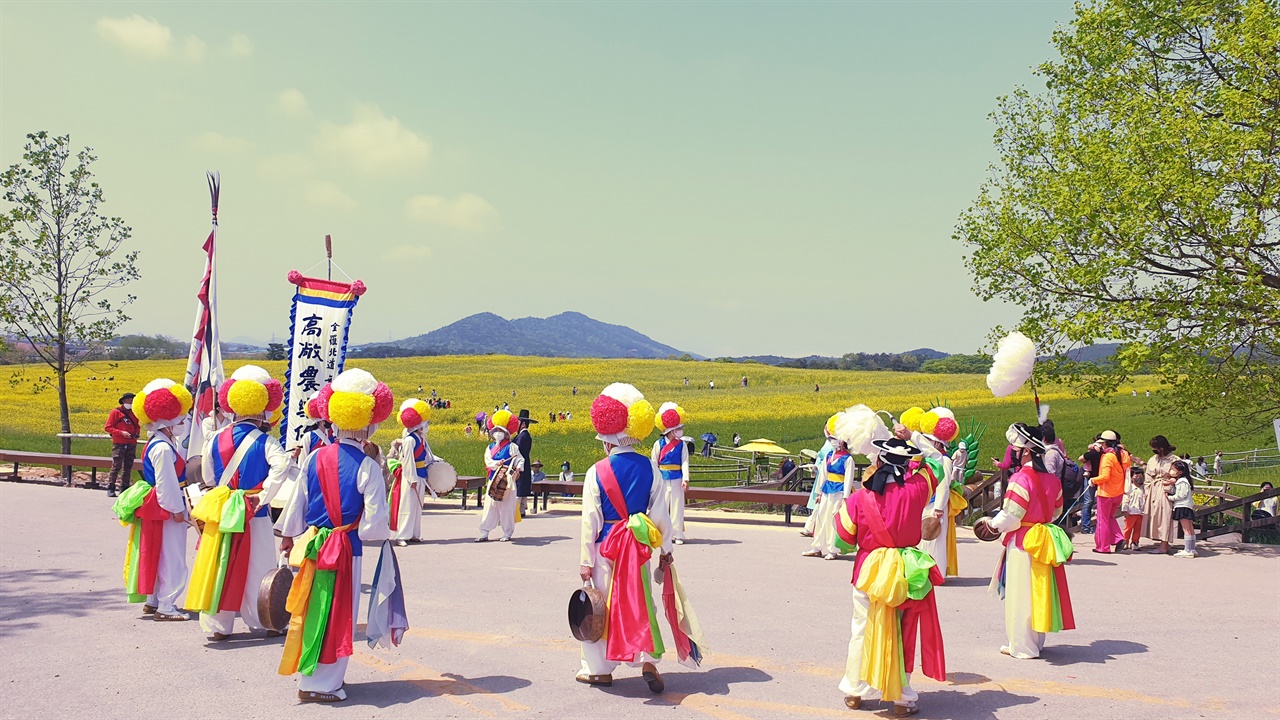 (사)고창농악 보존회가 공연하는 전통연희 퍼레이드 ‘복 놀이 가세’... 유채꽃과 청보리 사잇길을 걸으며 하는 농악놀이다. 