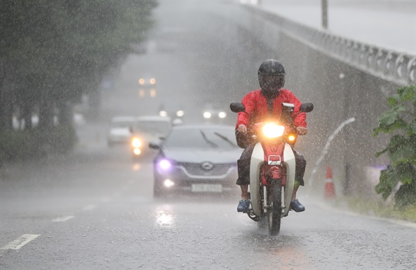 가을장마의 영향으로 전국적으로 많은 비가 내린 2021년 8월 21일 오후 서울 시내의 한 도로 위로 배달라이더가 비를 맞으며 길을 지나고 있다.