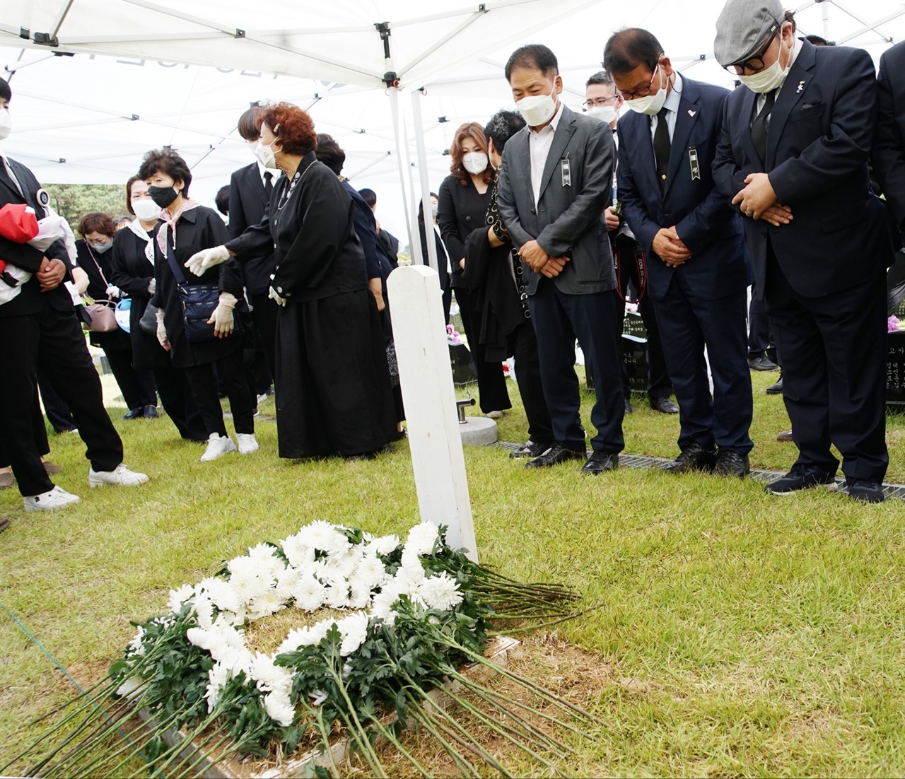 고 정동년 5.18기념재단의 안장식이 5.18국립묘지에서 거행된 후 참석자들이 묵념을 올리고 있다