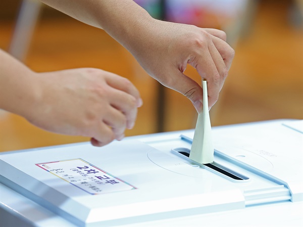제8회 전국동시지방선거일인 1일 오전 서울 서대문구 홍은2동 주민센터에 마련된 투표소를 찾은 유권자가 투표함에 투표용지를 넣고 있다. 
