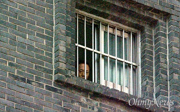 2004년 10월 19일 서울 용산구 남영동 보안분실 앞에서 국가보안법 피해자들이 국가보안법의 폐해를 낱낱이 지적하자 대공분실 안에서 한 사람이 지켜보고 있다. 자료사진.