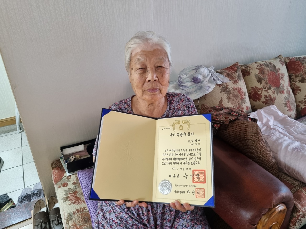 할아버지의 국가유공자 증서를 안고 있는 할머니의 모습.