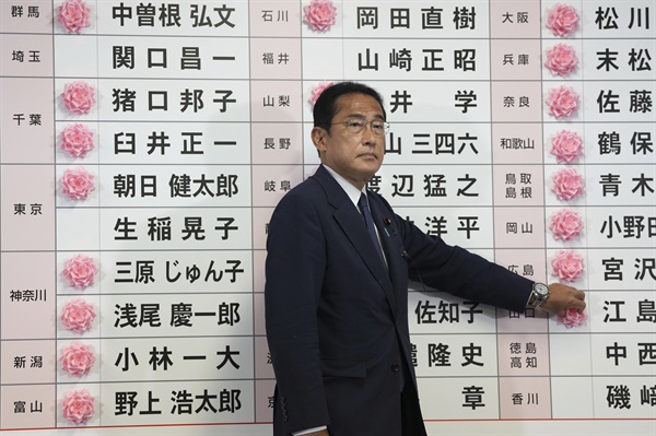 기시다 후미오 일본 자민당 총재(현 일본 총리)가 지난 10일 도쿄 자민당 당사에서 참의원선거 당선자 이름에 당선을 의미하는 스티커를 붙이고 있다. 