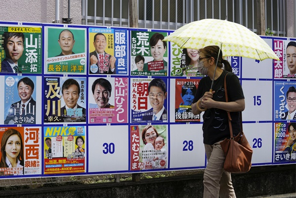 지난 10일 일본 도쿄의 한 투표소 밖에서 유권자가 참의원선거 후보 벽보를 살펴보고 있다. 