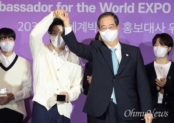  19일 서울 용산구 하이브엔터테인먼트에서 열린 2030 부산세계박람회 홍보대사 위촉식에서 한덕수 국무총리가 방탄소년단 슈가의 손을 들어올려 보이고 있다. 