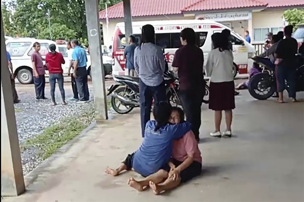 10월 6일 태국 농부아람푸주 나끌랑 지역의 한 어린이집에서 전직 경찰관에 의한 총기난사사건이 벌어진 가운데 한 여성이 어린이집 사고 현장 밖에서 위로를 받고 있다.