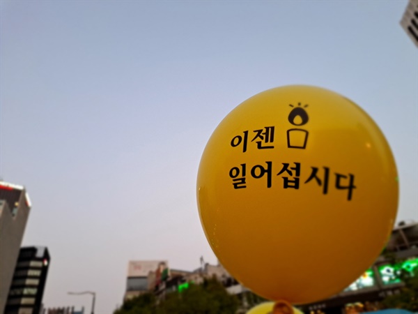 22일 오후 5시경 촛불행동 주최 제11차 촛불대행진이 진행된 서울시청 인근 숭례문 앞에서 한 시민이 든 "이젠 일어섭시다"라는 풍선이 돋보인다.
