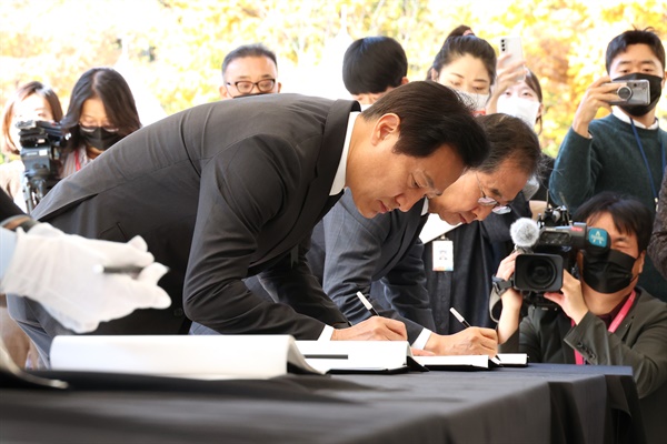 오세훈 서울시장(왼쪽)이 31일 서울 중구 서울광장에 마련된 이태원 참사 합동분향소에서 참배를 마친 후 방명록을 작성하고 있다.