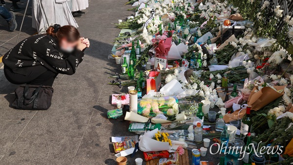 10월 31일 오후 서울 용산구 이태원역 1번 출구앞에 마련된 이태원 압사 참사 희생자 추모공간에서 내외국인들이 희생자들을 추모하고 있다.