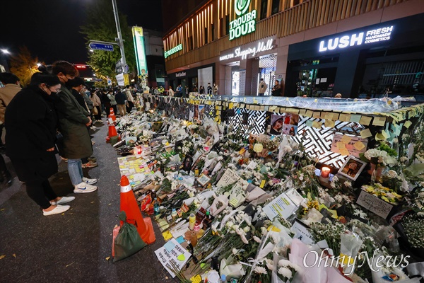 지난 3일 저녁 서울 용산구 이태원역 1번 출구에서 내외국인들이 이태원 압사참사 희생자들을 추모하고 있다.