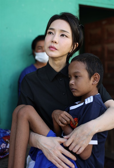 윤석열 대통령 배우자 김건희 여사가 지난 12일(현지시간) 캄보디아 프놈펜의 한 선천성 심장질환을 앓고 있는 14세 환아의 집을 찾았다. 김 여사는 아이를 어린 아이처럼 안고 사진을 찍었다. 