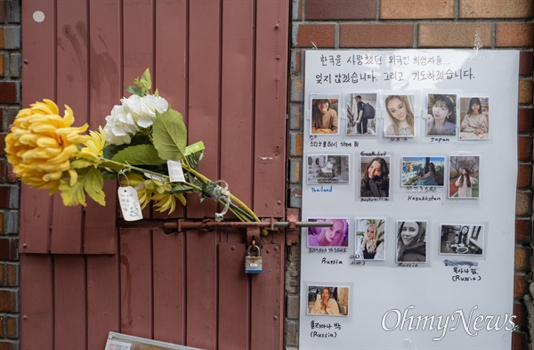 10월 14일 오후 이태원압사참사가 발생한 서울 용산구 해밀톤호텔 일대 골목의 통제가 풀리자 외국인 희생자의 사진과 꽃이 함께 남아 있다. 