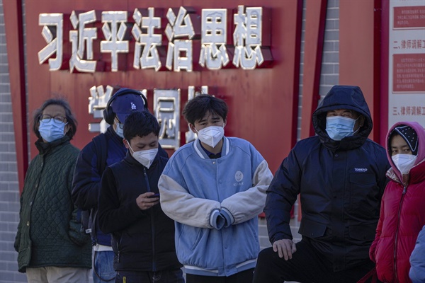 5일 베이징에서 "시진핑 법치 사상 학습원"이라는 문구가 적힌 벽을 따라 코로나 검사를 받기 위해 주민들이 기다리고 있다.