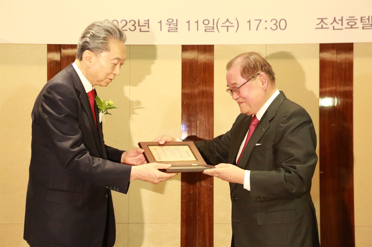 11日午後、ソウルのウェスティン朝鮮ホテル2階の宴会場で、ウダン財団主催の鳩山由紀夫元首相の「ウダン特別表彰式」が行われた。 写真は、鳩山総理に賞状を贈るイ・ジョンチャン大統領。