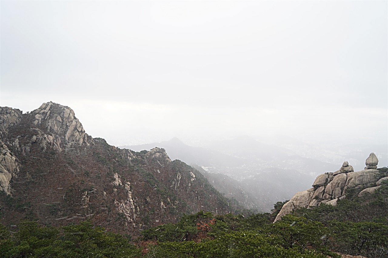 북한산 문수봉에서 바라본 보현봉과 오른쪽 두꺼비바위. 눈보라가 몰아친다.