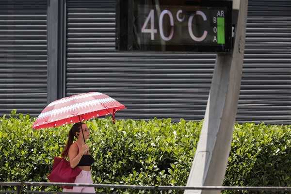 지난 14일 브라질 상파울루의 도시 온도계가 섭씨 40.0도를 기록했다. 파울리스타 거리에서 한 젊은 여성이 우산으로 햇볕을 가리고 있다. 