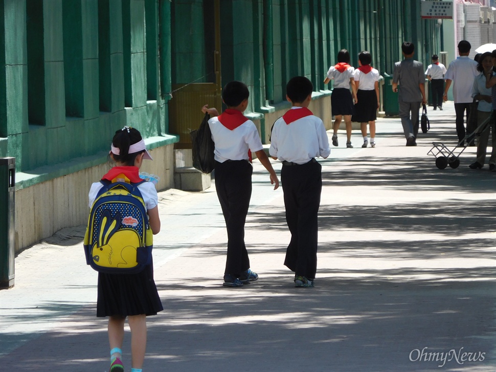  평양 길거리를 걸어가는 북한 학생들.