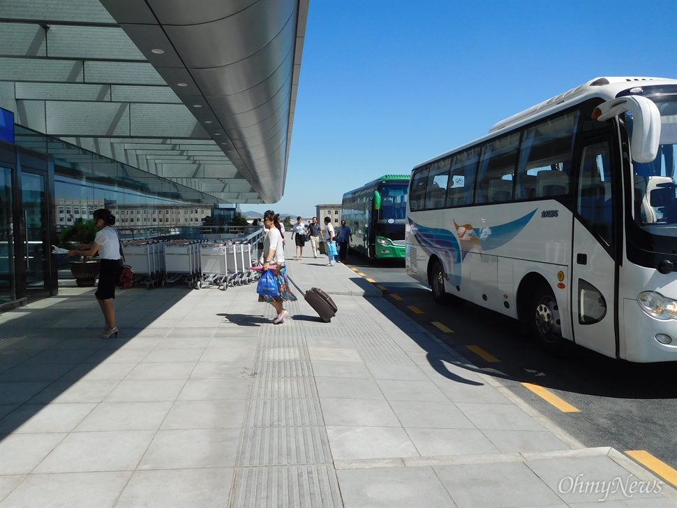  평양 순안공항 외관. 버스에서 내린 이용객들이 공항 안으로 들어가고 있다.