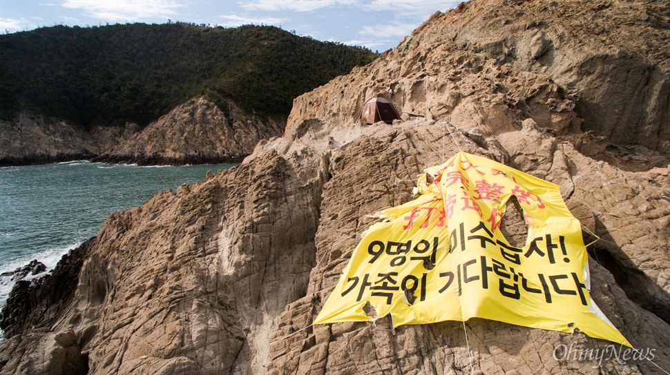 인양선을 향해 쓰여진 '찢어진 현수막' 세월호 인양선 감시를 나선 세월호 유가족들이 설치한 현수막. 중국어와 한국어로 "9명의 미수습자! 가족이 기다립니다"라고 쓰여있다. 이 현수막은 강한 바다 바람으로 인해 찢겨 져 있다. 