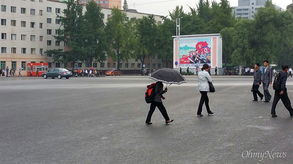  8일 촬영한 평양의 거리. 한 여성이 우산을 쓴 채 걸어가고 있다.