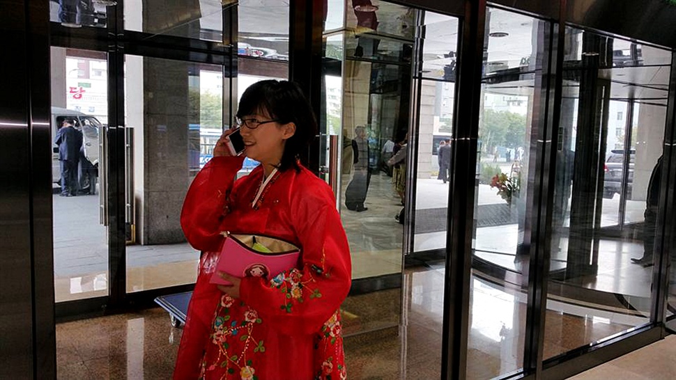  이번 북한 여행의 안내를 맡은 최경미 안내원. 8일 고려호텔 로비에서 북한산 스마트폰 '아리랑'으로 통화하고 있는 모습이다. 조선노동당 창건 70주년 명절을 맞아 북한의 안내원들은 주로 한복을 입고 있었다. 