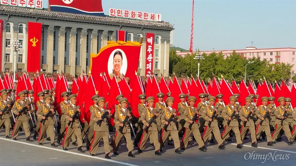  인민군의 행진 모습. 깃발 모양의 구조말 안에는 김정일 위원장의 얼굴이 담겨 있다.