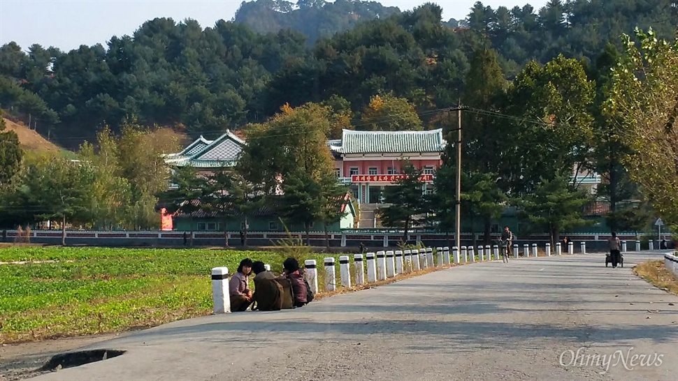  북한 자강도의 한 농촌. 텃밭 앞에 여성 세 명이 옹기종기 앉아 있다. 