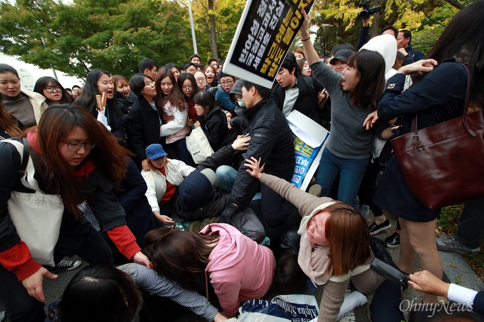 "밀지마!" 쓰러진 이대생들 29일 오후 서울 이화여대 대강당에서 열리는 전국여성대회에 박근혜 대통령이 축사를 위해 방문하는 가운데, 역사교과서 국정화와 쉬운해고 등 노동개악에 반대하는 이대생들이 방문반대 시위를 벌였다. 학생들이 대통령에게 자신들의 의사를 전달하겠다며 대강당으로 이동하는 과정에서 저지하는 사복경찰과 충돌이 벌어졌고, 일부 학생들이 뒤엉켜 넘어지고 있다.