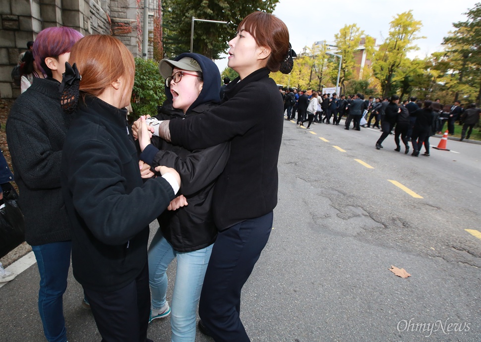 사복경찰에 붙잡힌 이대생 29일 오후 서울 이화여대 대강당에서 열리는 전국여성대회에 박근혜 대통령이 축사를 위해 방문하는 가운데, 역사교과서 국정화와 쉬운해고 등 노동개악에 반대하는 이대생들이 방문반대 시위를 벌였다. 학생들이 대통령에게 자신들의 의사를 전달하겠다며 대강당으로 이동하는 과정에서 저지하는 사복경찰들과 학내 곳곳에서 충돌이 벌어져 일부 학생들이 넘어져 부상을 당하기도 했다.