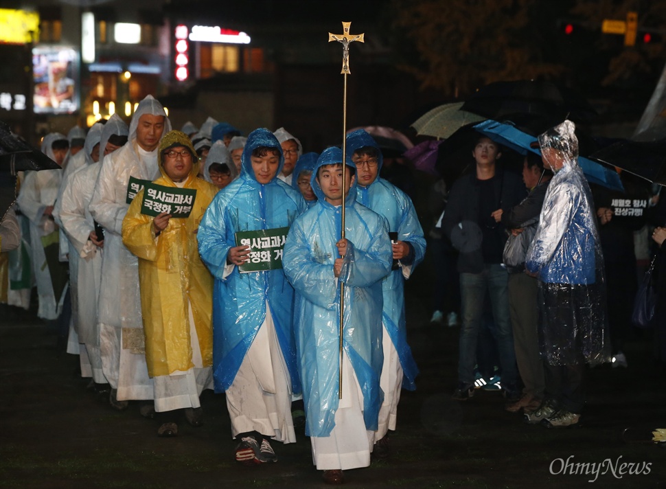 십자가 앞세우고 시국기도회 입장하는 천주교정의구현사제단 천주교정의구현사제단 소속 신부들이 16일 오후 서울 중구 서울시청광장에서 열린 '역사교과서 국정화, 노동개악 반대 비상시국기도회'에 입장하고 있다.
이날 이들은 "역사교과서 국정화로 미래 세대의 역사관마저 왜곡시키려 하고 있다"며 "대통령과 정부는 오로지 유신의 부활과 권력 영구화만을 꿈꾸고 있다"고 규탄했다.
