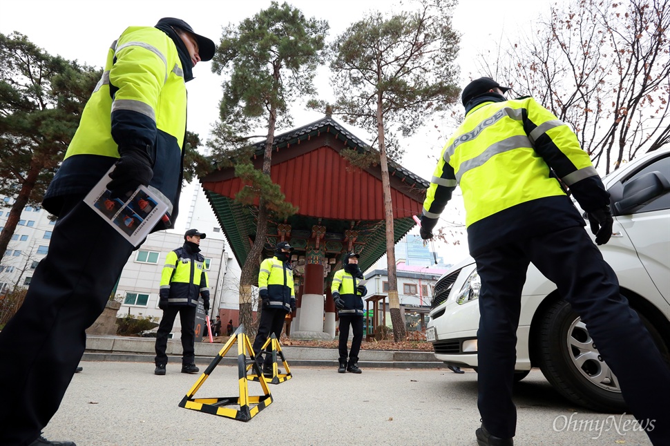 한상균 위원장 사진 든 경찰들, 조계사 출입 차량 검문검색 수배중이던 민주노총 한상균 위원장이 11.14민중총궐기 대회 직후 종로구 견지동 조계사로 몸을 피한 가운데 27일 오전 조계사 입구에서 경찰들이 출입하는 차량을 검문검색하고 있다. 경찰들 손에는 한상균 위원장의 삭발 전후 모습이 담긴 사진이 들려 있다.