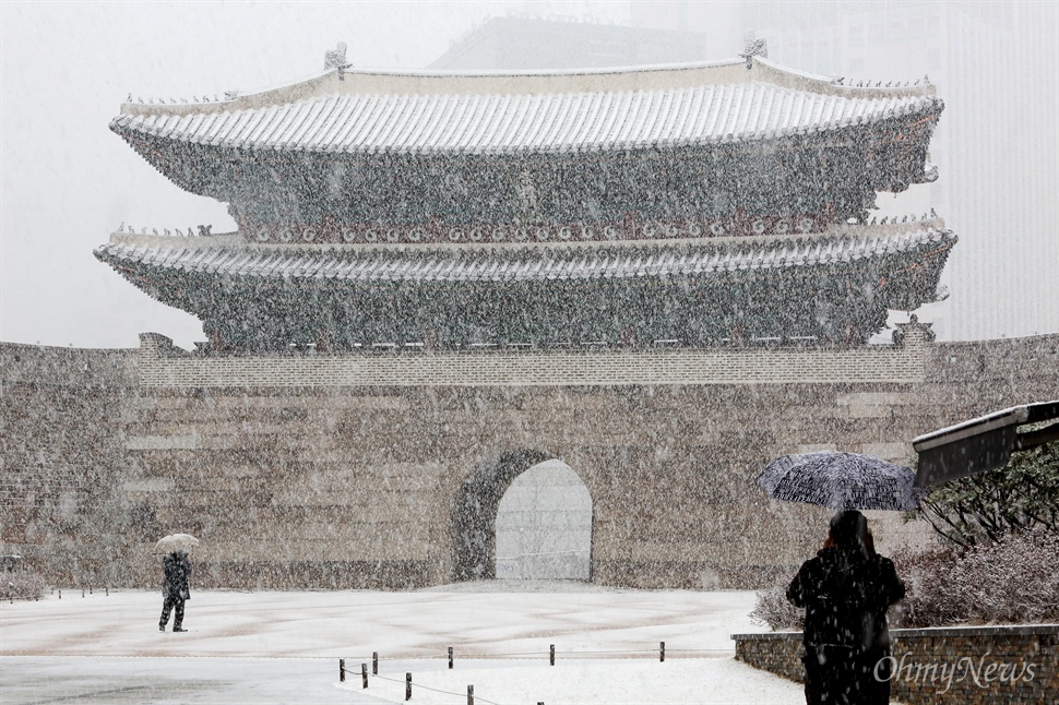 폭설 쏟아지는 남대문시장 서울에 올겨울 첫 대설주의보가 발령된 3일 오전 카메라를 든 시민들이 눈 내리는 숭례문 풍경을 사진에 담고 있다.