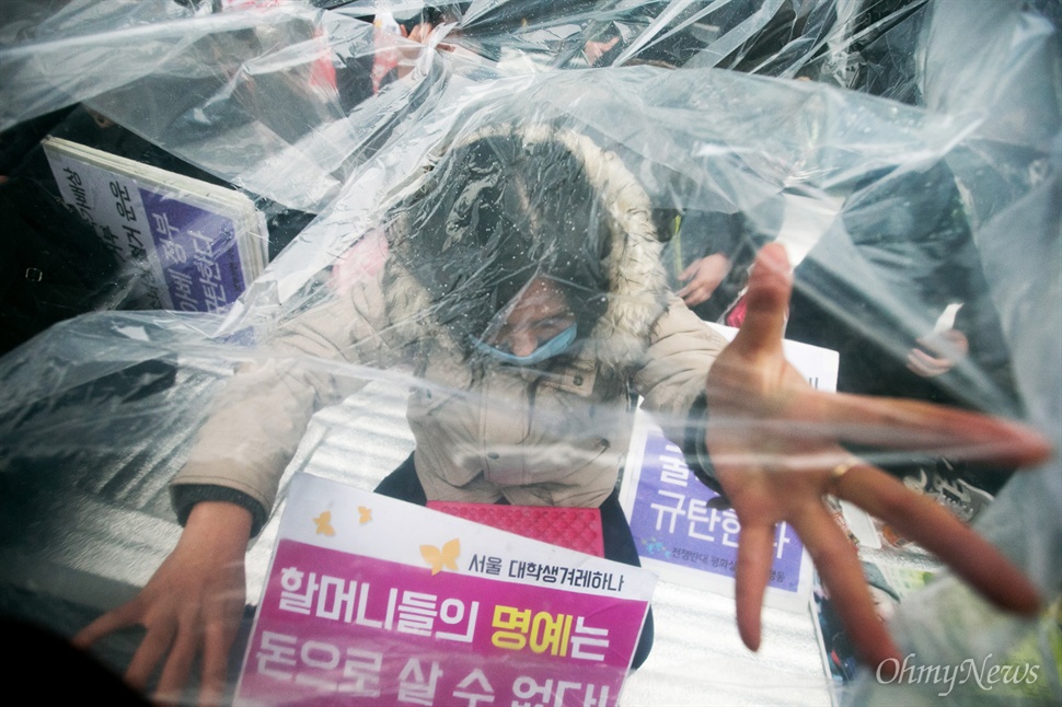  30일 오후 서울 종로구 일본대사관 앞에서 평화나비 네트워크 등 대학생들이 비를 맞으며 평화의 소녀상 비를 맞으며 주변 자리를 지키고 있다.
