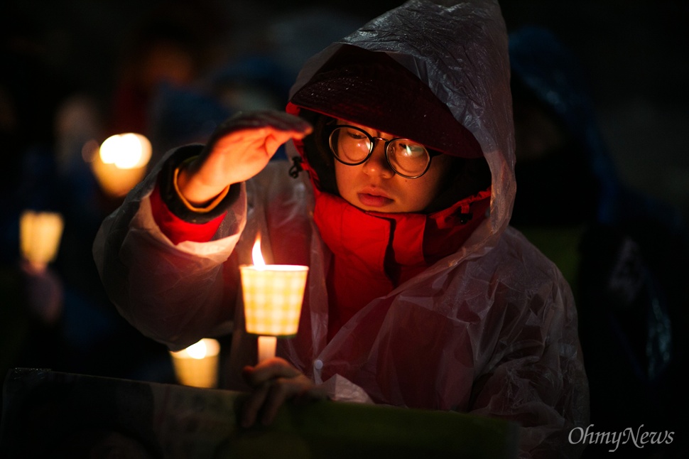 '촛불 꺼지면 안되요' 30일 오후 서울 종로구 일본대사관 앞에서 평화나비 네트워크 등 대학생들이 비를 맞으며 평화의 소녀상 주변 자리를 지키고 있다.